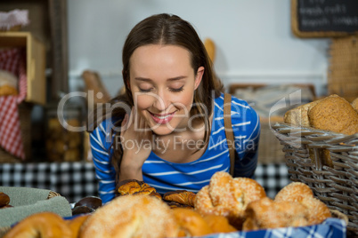 Smiling woman smelling a breads at counter