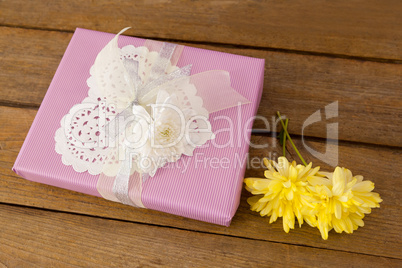 Gift box with flowers on wooden table