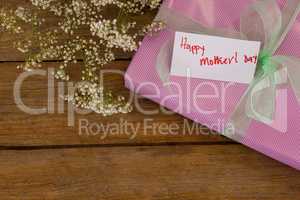 Happy mothers day card on gift box with flowers