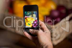 Hand of man taking photo of vegetables