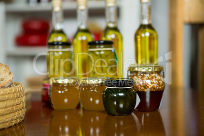 Olive oil, jam, pickle placed together on table