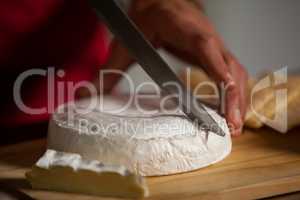 Staff cutting cheese at counter in market