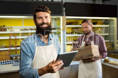 Portrait of smiling staff using digital tablet