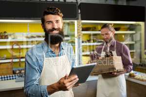 Portrait of smiling staff using digital tablet