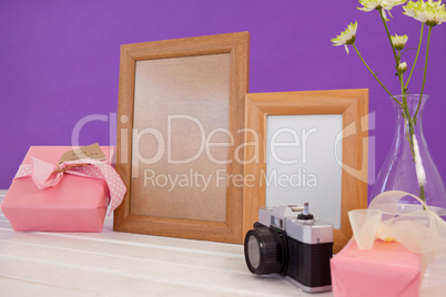 Happy mothers day card on gift box with wooden frames and camera