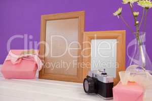 Happy mothers day card on gift box with wooden frames and camera