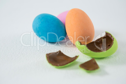 Broken chocolate Easter egg against three chocolate Easter egg
