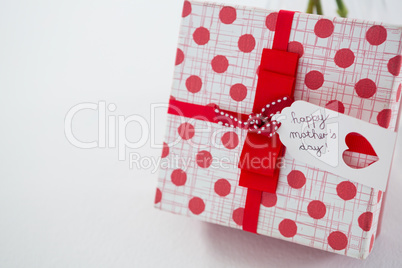 Gift box with happy mothers day tag on white background