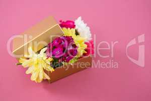 Gift box full of flower against pink background