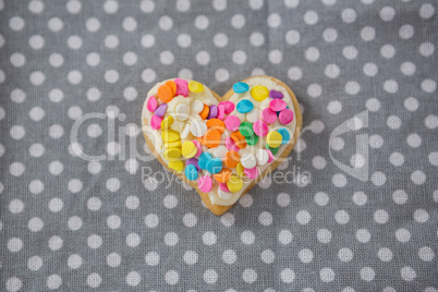 Decorated heart shape cookie against polka dot background