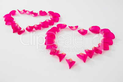 Rose petals forming heart shape against white background