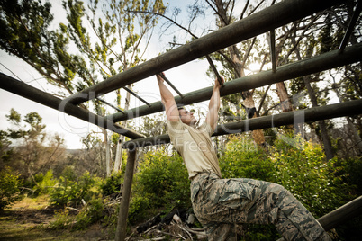 Soldier climbing monkey bars