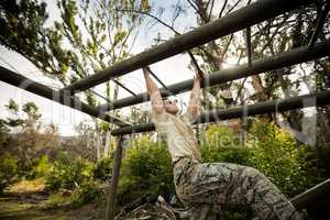 Soldier climbing monkey bars