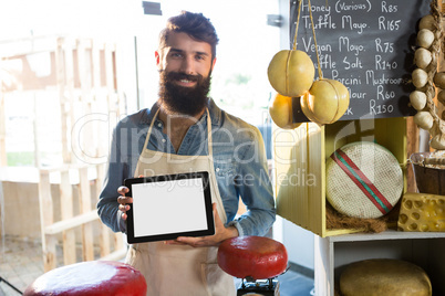 Portrait of staff showing digital tablet at counter