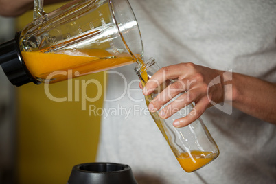 Male staff pouring juice in a bottle