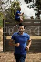 Fit man running during obstacle course