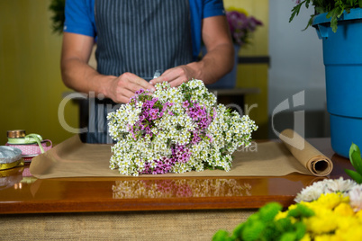 Male florist preparing a flower bouquet