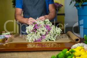 Male florist preparing a flower bouquet