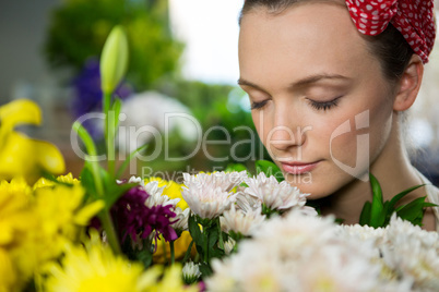 Female florist smelling a bunch of flower