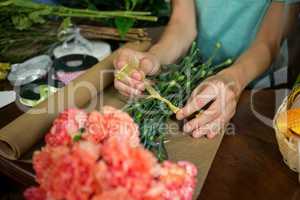 Female florist preparing bunch of flower in flower shop