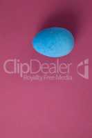 Blue Easter egg on pink background