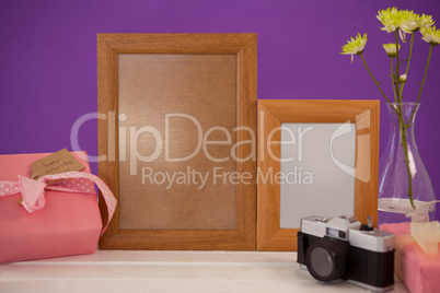 Happy mothers day card on gift box with wooden frames and camera