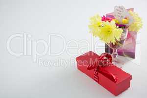 Gift box and flowers in glass with happy mothers day tag