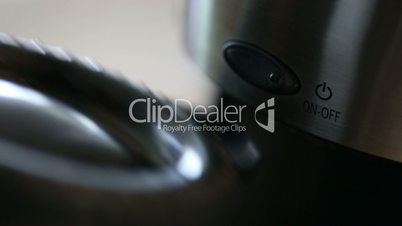 Close-up of Woman Placing Coffee Pot Into Coffee Maker and Pressing The Power Button.