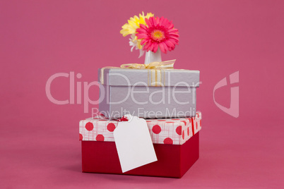 Stack of gift boxes with tag and flowers