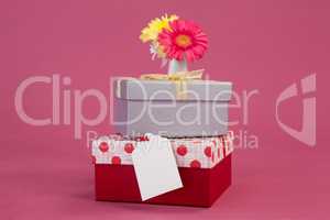 Stack of gift boxes with tag and flowers
