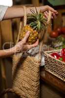 Woman buying pineapple at organic section