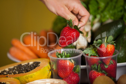 Hand of male staff holding strawberry