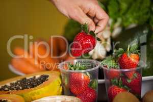 Hand of male staff holding strawberry