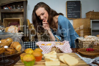 Excited woman purchasing sweet food at bakery counter