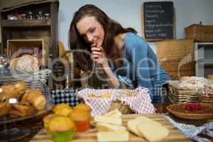 Excited woman purchasing sweet food at bakery counter
