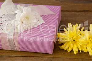 Gift box with flowers on wooden table