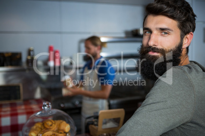 Portrait of male customer standing at counter