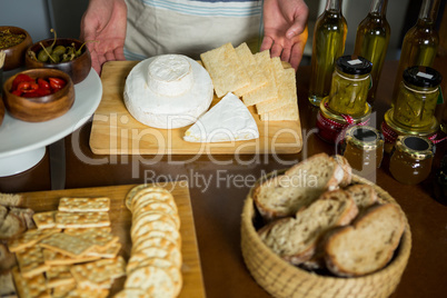 Staff standing near various cheeses at counter