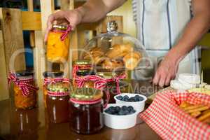 Shop assistant arranging jam and pickle jars