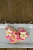 Heart shape cookies in plate on wooden plank