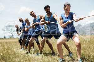 People playing tug of war during obstacle training course