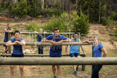 Group of people leaning on hurdles during obstacle training