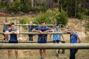 Group of people leaning on hurdles during obstacle training