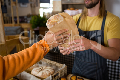 Male customer receiving a parcel from staff at counter