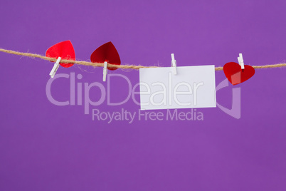 Blank card and red hearts hanging on the rope