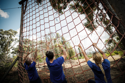 People climbing a net during obstacle course