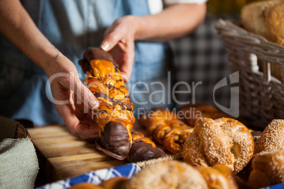 Mid-section of female staff arranging sweet foods