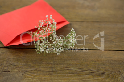 White flower in envelope on wooden plank