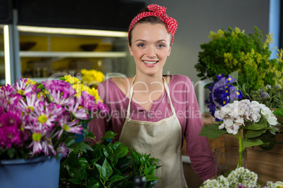 Happy female florist standing in flower shop