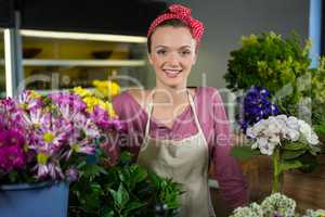 Happy female florist standing in flower shop